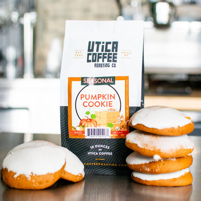 Pumpkin cookies with a bag of Utica Coffee on a metal surface
